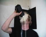 Babyface (2009) Der Künstler trinkt, beklebt mit einem Stück Schafsfell, Milch aus einer schwarzen Milchtüte. Dauer: 01:10 min.